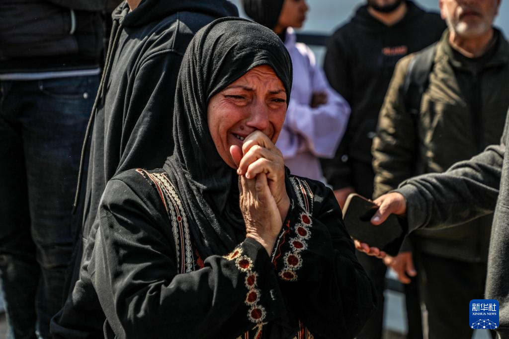 4月9日，在加沙地带中部代尔拜拉赫一所医院，一名女子在遇难记者的葬礼上哭泣。新华社发（里泽克·阿卜杜勒贾瓦德 摄）