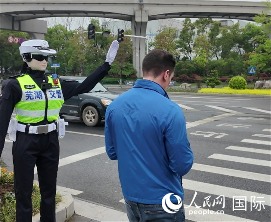 芜湖机器人交警拦下了不小心闯红灯的湖长明。人民网 张凯伟摄