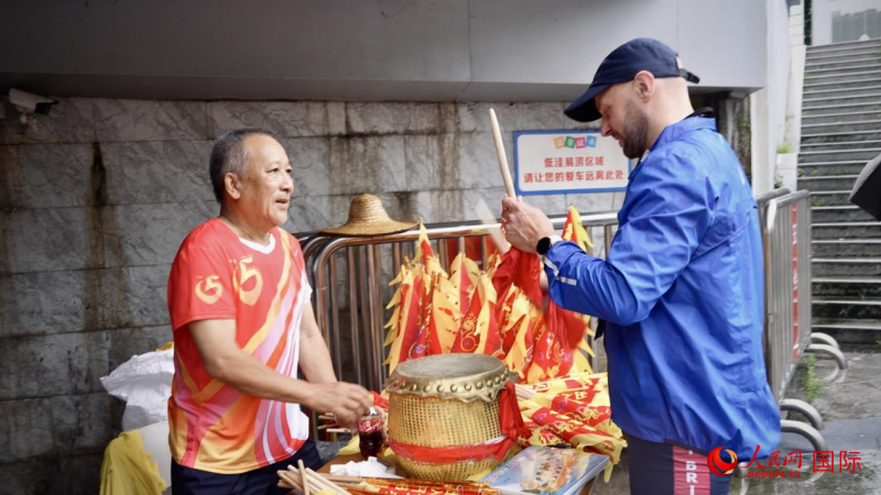 英国龙舟协会会长科林·史密斯现场体验敲鼓。人民网 吴宇扬扬摄