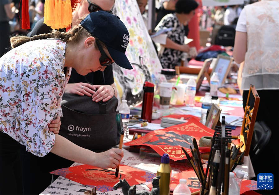 8月29日，在美国首都华盛顿，一名女子在第24届华盛顿中国文化节展位体验用毛笔写福字。新华社记者 李睿 摄