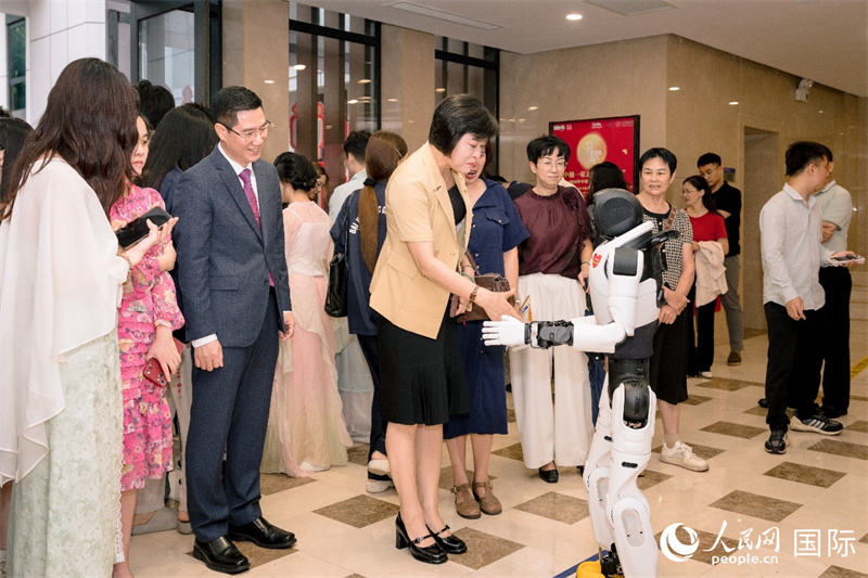 河内市友好组织联合会常务副主席陈氏芳与AI智能机器人互动。 人民网记者 白晓川摄