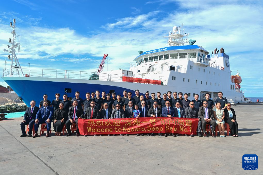 10月26日,应中国驻瑙鲁大使馆邀请,瑙鲁总统阿迪昂(前排中)、议长斯蒂芬(前排左七)等人登船参加开放日活动,并在瑙鲁艾沃港靠泊的“深海一号”船前与科考队员们合影。新华社记者 李鑫 摄