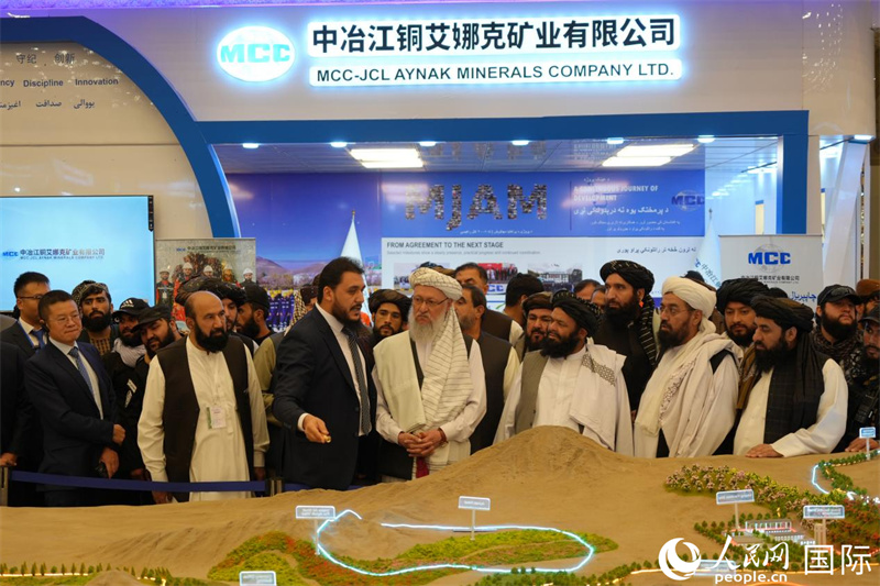 艾娜克矿业公司员工哈米德在该公司展位前向阿富汗行政事务副总理哈纳菲介绍矿区规划沙盘。人民网记者 章凯风摄