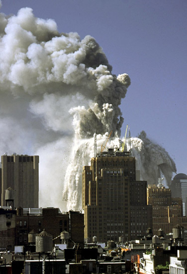 男子走在附近的街道上 当天纽约世贸大厦遭受飞机撞击瞬间的拼版照片