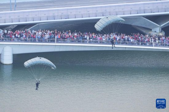 这是8月9日在新加坡滨海湾举行的60周年国庆庆典上拍摄的跳伞表演。新华社发（邓智炜摄）