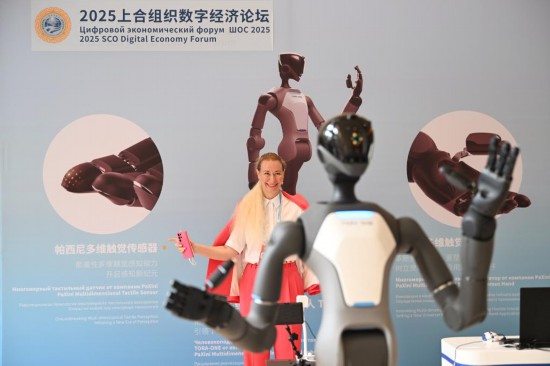 7月11日，参会嘉宾在2025上合组织数字经济论坛上体验操控人形机器人。新华社记者李然摄