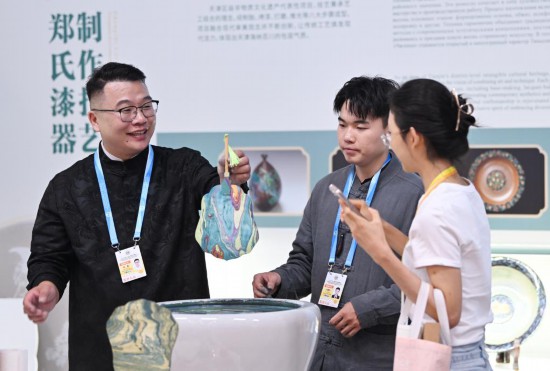 在2025年上海合作组织峰会新闻中心非遗互动展示区，郑勇向参观者演示漂流漆技法。新华社记者李然摄