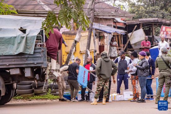 10月12日,在喀麦隆西南大区首府布埃亚,选举工作人员和安保人员在投票站开放前准备投票材料。新华社发(穆朗·廷古姆摄)
