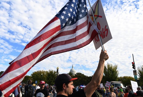 10月18日,在美国华盛顿,人们参加示威游行活动。新华社记者李睿摄