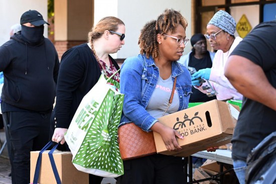 10月21日，在美国马里兰州海厄茨维尔市，联邦雇员领取免费食品。新华社记者李睿摄