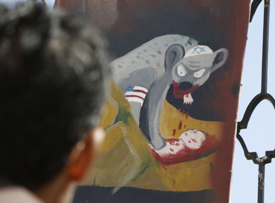 11月5日，一名男子在也门首都萨那街头观看揭露美国以色列暴行的宣传画。 新华社发（默罕默德·默罕默德摄）