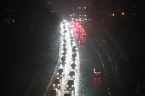 11月20日,乌克兰首都基辅主要街道的照明设施出现大面积停电,车辆在夜色中行驶。新华社记者李东旭摄