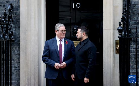 10月24日，在英国伦敦唐宁街10号首相府前，英国首相斯塔默（左）与到访的乌克兰总统泽连斯基交谈。新华社记者 李颖 摄