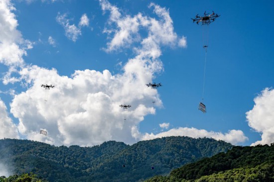 中老500千伏联网工程在施工过程中运用无人机集群作业方式开展施工物资运输。(张强 摄)