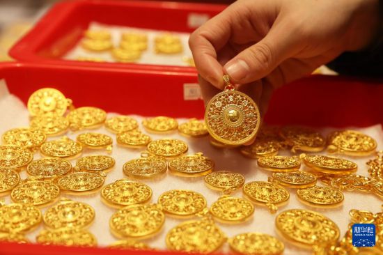 1月28日，员工在位于浙江省杭州市萧山区瓜沥镇的杭州航民百泰首饰有限公司展厅整理黄金首饰。新华社发（倪立芳摄）