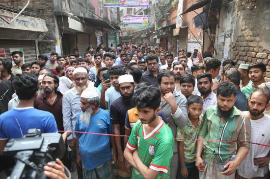 　　2025年11月21日，在孟加拉国首都达卡，人们聚集在房屋损毁现场附近。据孟加拉国媒体报道，孟加拉国首都达卡附近21日上午发生5.7级地震，已造成至少6人死亡、数人受伤。新华社发（哈比卜·拉赫曼摄）