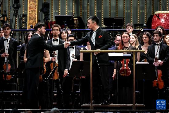 3月25日,在匈牙利布达佩斯,中国音乐学院院长李心草(前右)与匈牙利小提琴手握手。新华社发(鲍洛格·达维德摄)