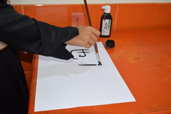 2025年4月20日，在也门亚丁，学生在联合国中文日活动上写毛笔字。新华社发