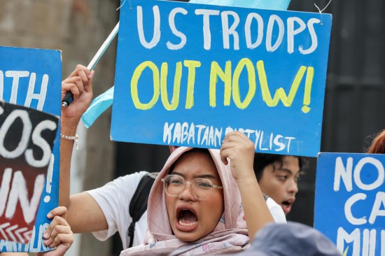 　　4月20日，民众手持标语在菲律宾武装部队总部外集会抗议美菲“肩并肩”联合军演。新华社发（乌马利摄）