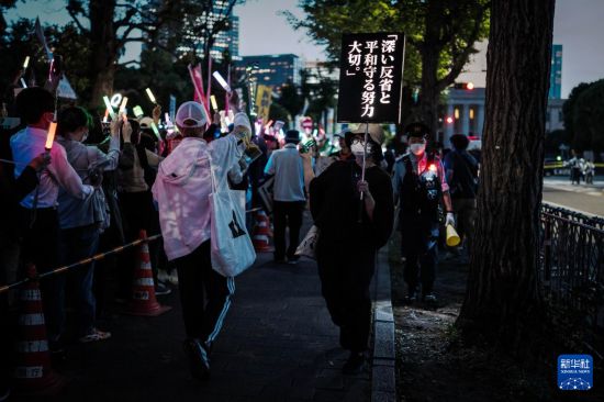 5月19日,在位于日本东京的国会议事堂前,民众手持标语参加抗议集会。新华社记者 贾浩成 摄