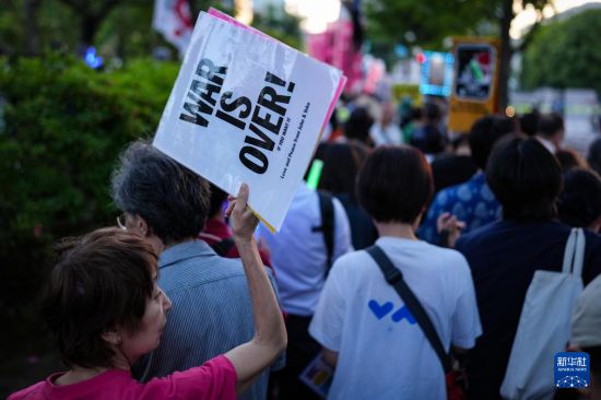 5月19日,在位于日本东京的国会议事堂前,民众手持标语参加抗议集会。新华社记者 贾浩成 摄