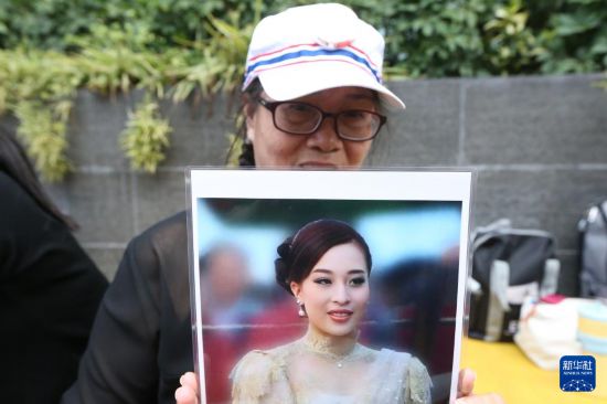 6月13日，手捧帕查拉吉迪雅帕公主肖像的民众在泰国曼谷朱拉隆功国王纪念医院门口悼念。新华社发（拉亨摄）