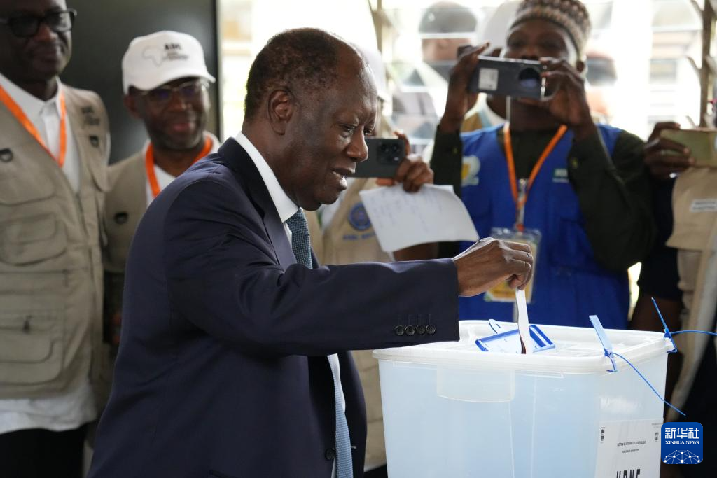 10月25日，在科特迪瓦经济首都阿比让的一处投票站，科特迪瓦现任总统阿拉萨内·瓦塔拉将选票放入投票箱。新华社记者 张健 摄