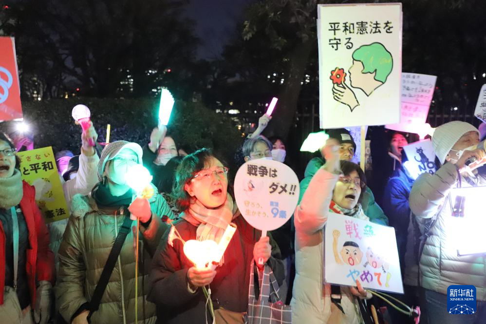 3月10日,在位于东京的日本国会门前,民众手持标语参加抗议活动。新华社记者 李子越 摄