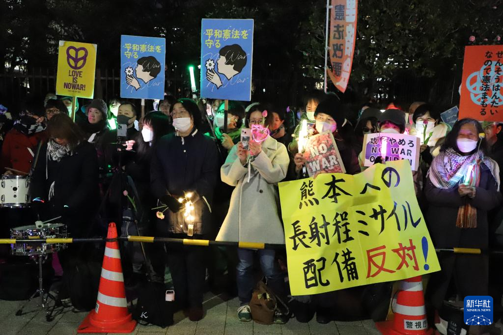 3月10日,在位于东京的日本国会门前,民众手持标语参加抗议活动。新华社记者 李子越 摄